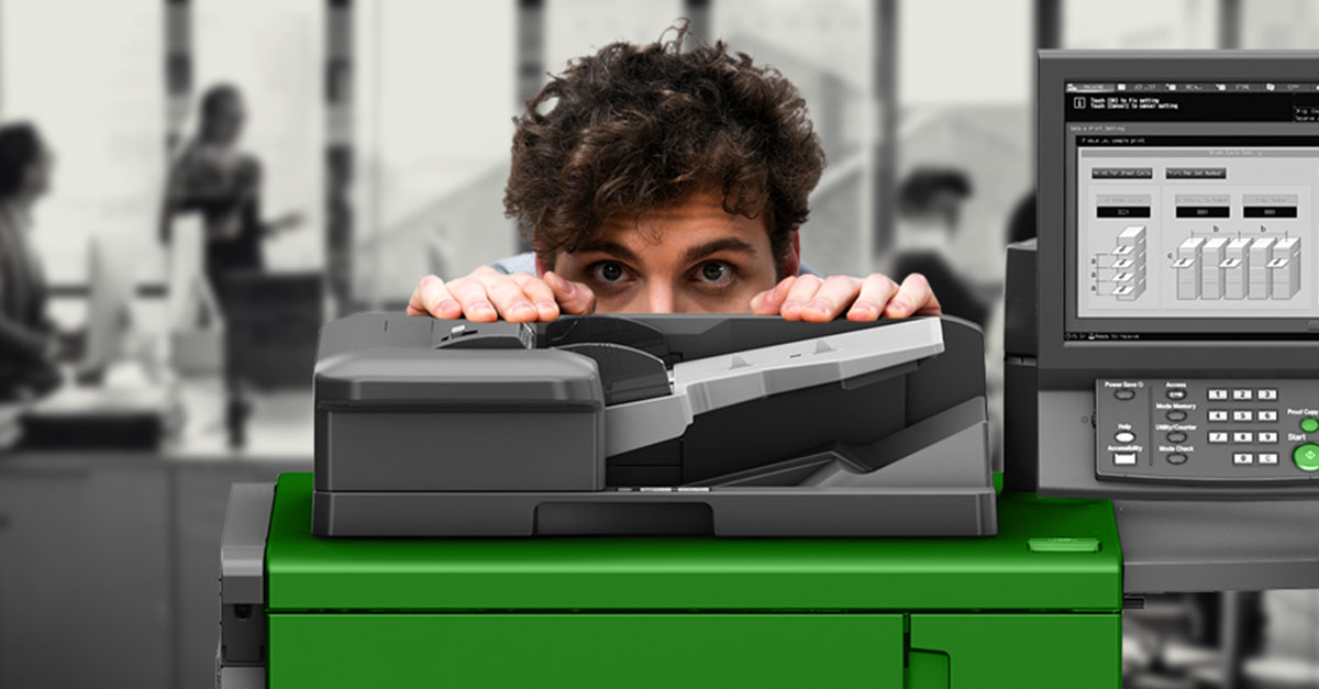 Man in office hiding behind a printer